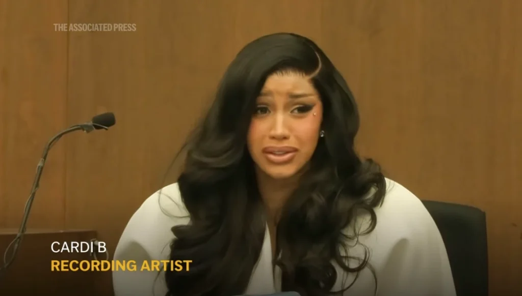 Карди Би выступает за трибуной в зале суда